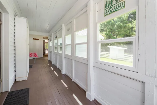 a view of hallway with wooden floor and a window