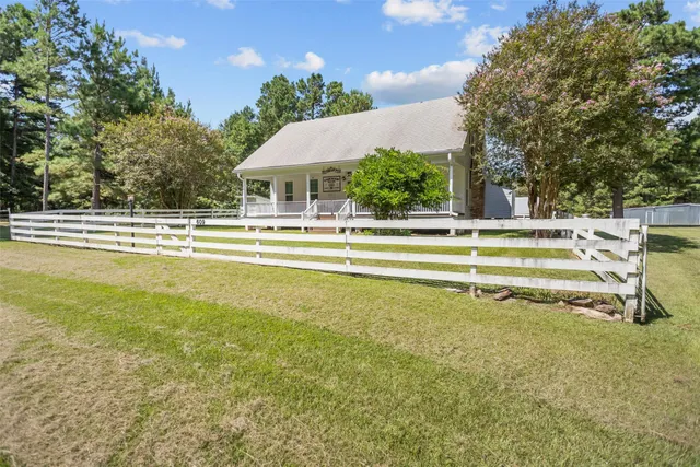 a view of an house with swimming pool and trees in the background