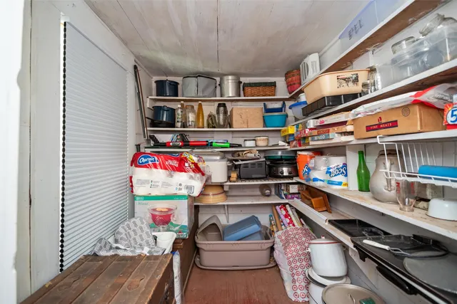 a utility room with stainless steel appliances lots of clutter