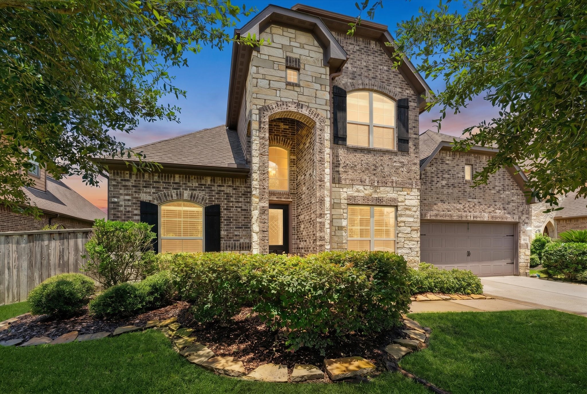 2506 Barclay Lake Lane Spring, TX 77388 - Photo 25 of 35 Curb appeal that stops you in your tracks with a striking stone and brick exterior, framed by mature trees and fresh mulch beds and lush landscaping.