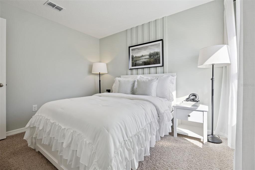 3451 Nettle Loop Tavares, FL 32778 - Photo 20 of 29 a bedroom with a bed and a lamp