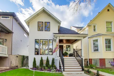 a front view of a house with a yard and potted plants