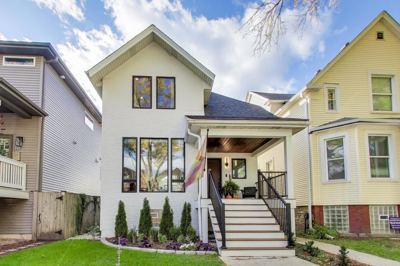 a front view of a house with a yard and potted plants