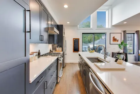 a kitchen with stainless steel appliances granite countertop a sink a stove and a refrigerator