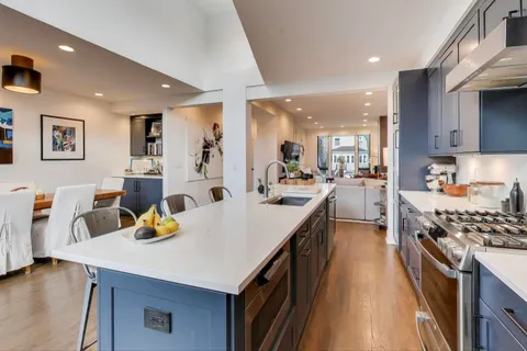 a kitchen with a sink a stove and chairs