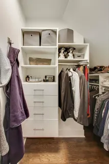 a view of walk in closet with clothes and shoes