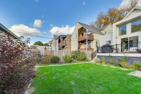 a view of a backyard with table and chairs potted plants and a palm tree
