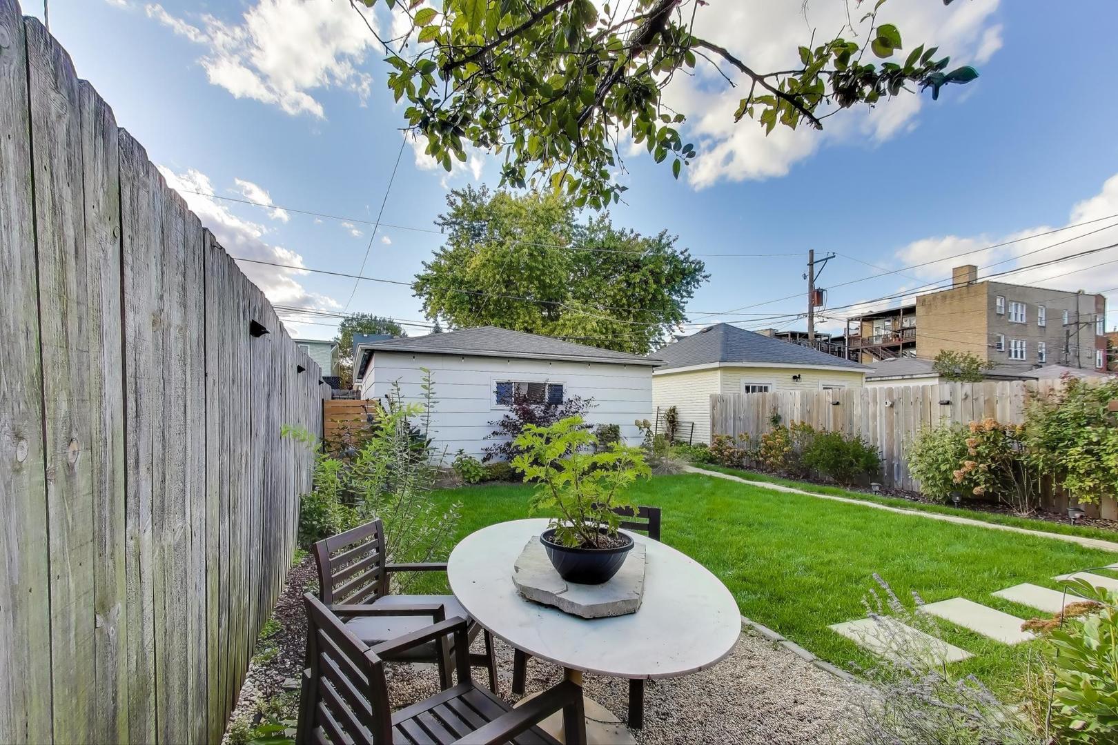 4438 North Spaulding Avenue Chicago, IL 60625 - Photo 37 of 40 a view of a backyard with table and chairs potted plants and a palm tree