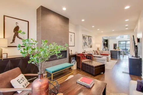 a living room with furniture flowerpot and wooden floor