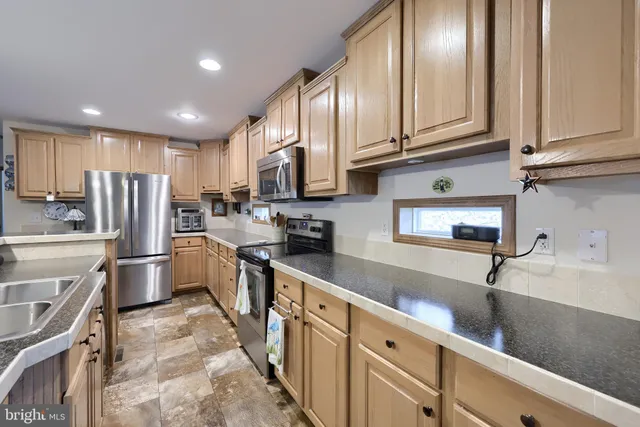 a kitchen with stainless steel appliances granite countertop a refrigerator sink and cabinets