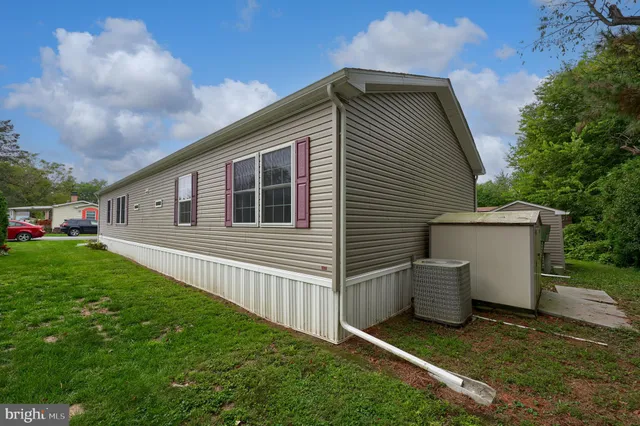 a view of backyard of house with wooden fence