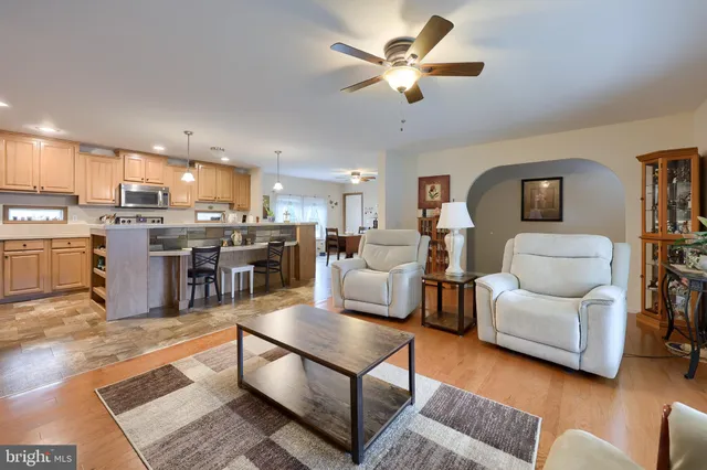 a living room with furniture kitchen view and a chandelier