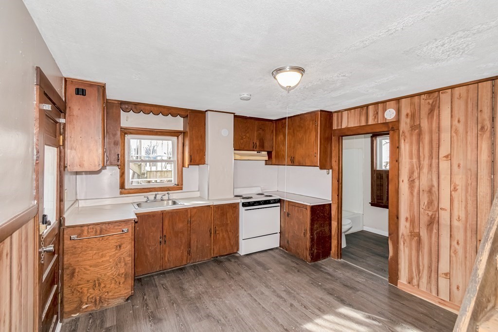 12 Cherry Street Westfield, MA 01085 - Photo 4 of 11 a kitchen with stainless steel appliances granite countertop wooden cabinets a sink and dishwasher a refrigerator with wooden floor