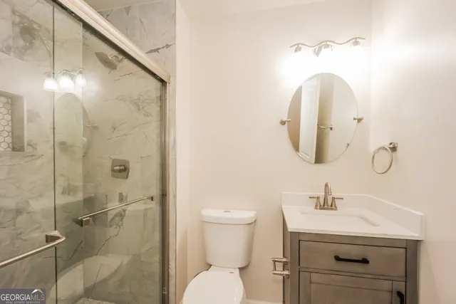 a bathroom with a sink mirror and toilet