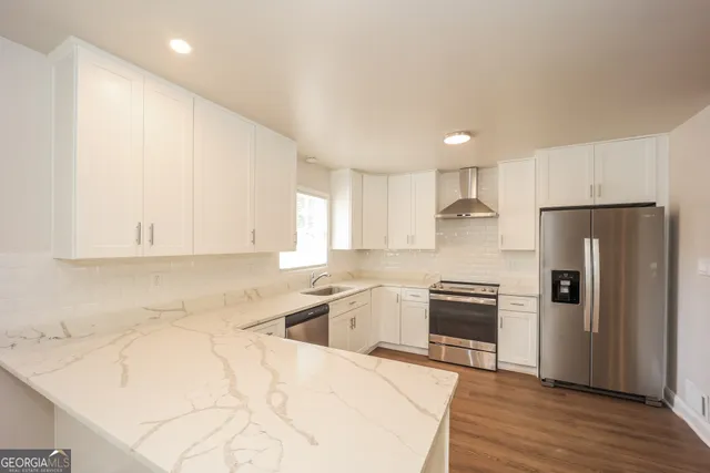 a kitchen with granite countertop a refrigerator sink and cabinets