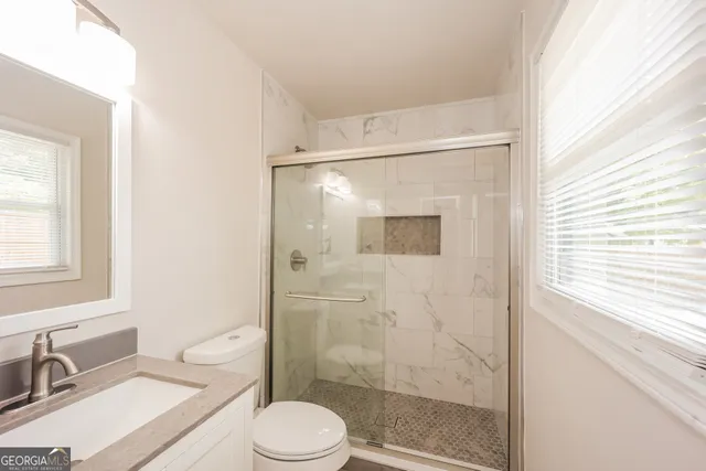 a bathroom with a sink a toilet and shower