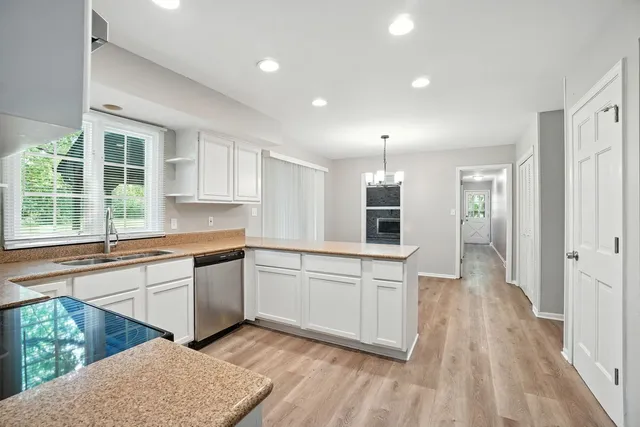 a large kitchen with stainless steel appliances granite countertop a refrigerator and a stove top oven