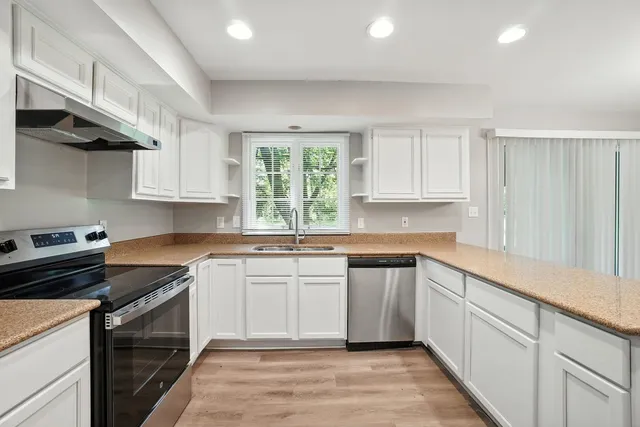 a kitchen with a sink stove top oven and cabinets