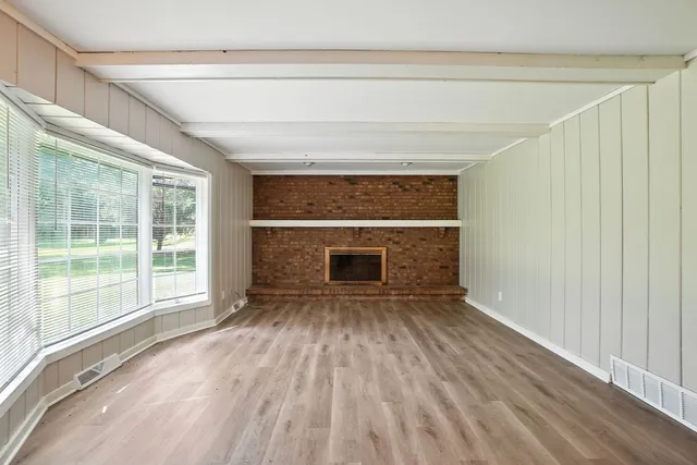 a view of empty room with a fireplace and wooden floor