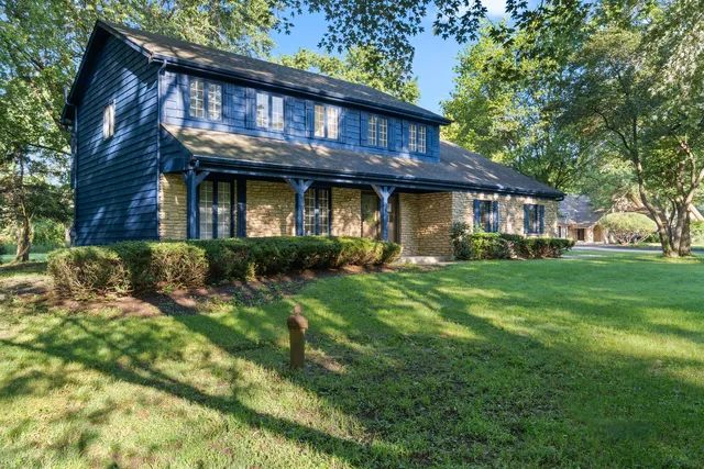 a front view of a house with a garden and plants