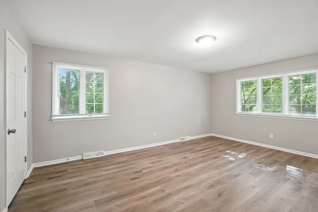 a view of a room with wooden floor and windows