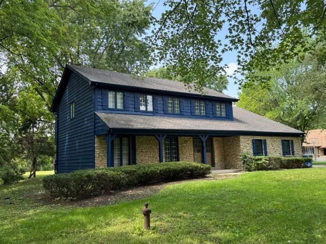a front view of a house with a garden