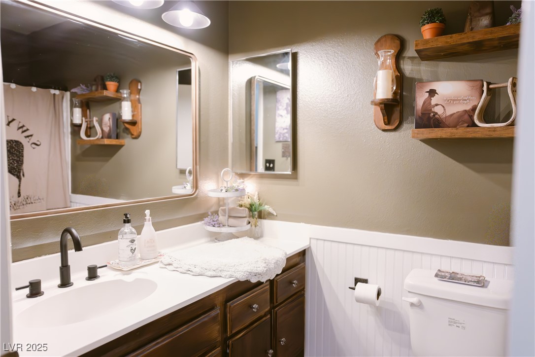 1515 Darlene Way Boulder City, NV 89005 - Photo 17 of 22 Bathroom with vanity, a shower with shower curtain, and wainscoting
