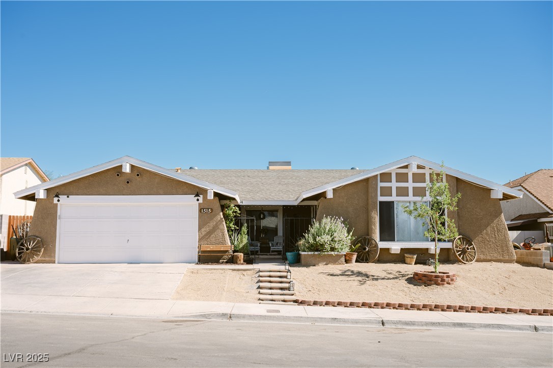 1515 Darlene Way Boulder City, NV 89005 - Photo 2 of 22 View of front of house with driveway, stucco siding, a garage, and a chimney