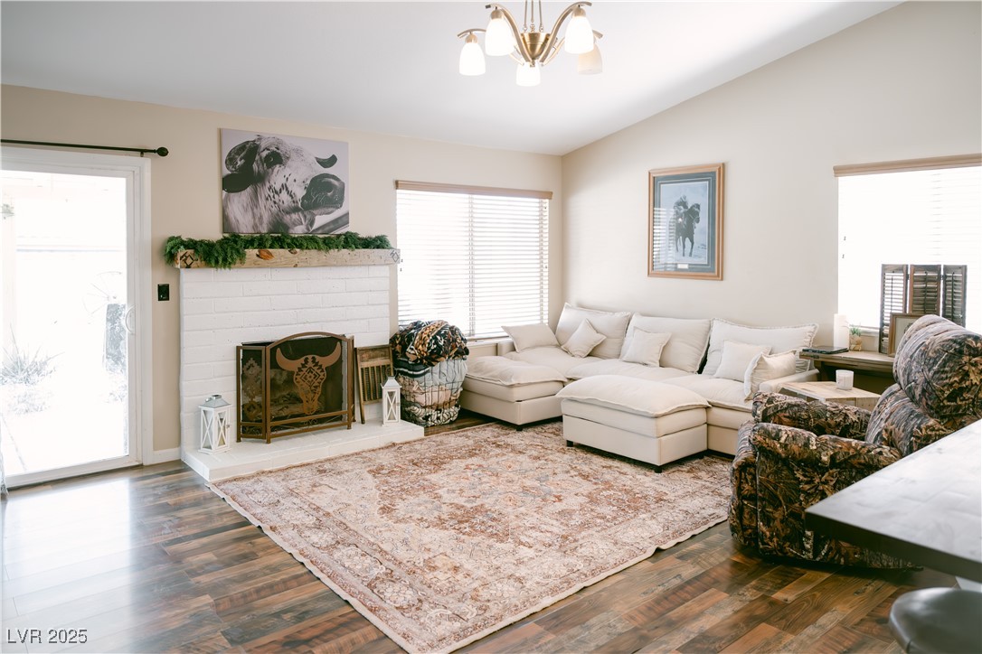 1515 Darlene Way Boulder City, NV 89005 - Photo 4 of 22 Living area with lofted ceiling, dark wood-type flooring, a chandelier, and a brick fireplace
