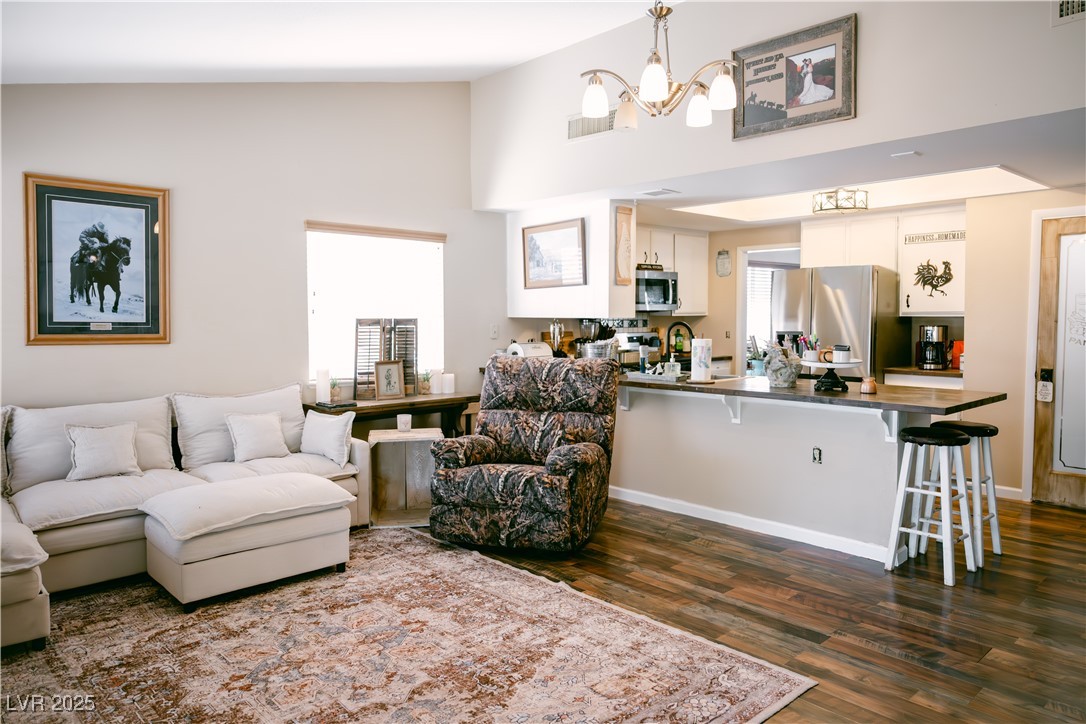 1515 Darlene Way Boulder City, NV 89005 - Photo 7 of 22 Living room with dark wood-style flooring, a chandelier, and high vaulted ceiling