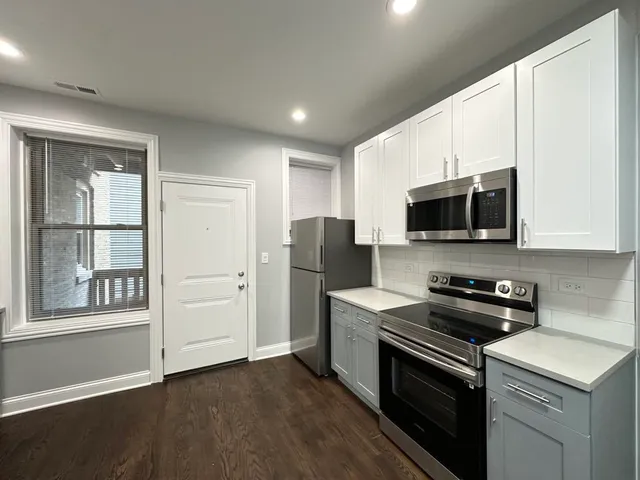 a kitchen with stainless steel appliances a stove microwave and sink