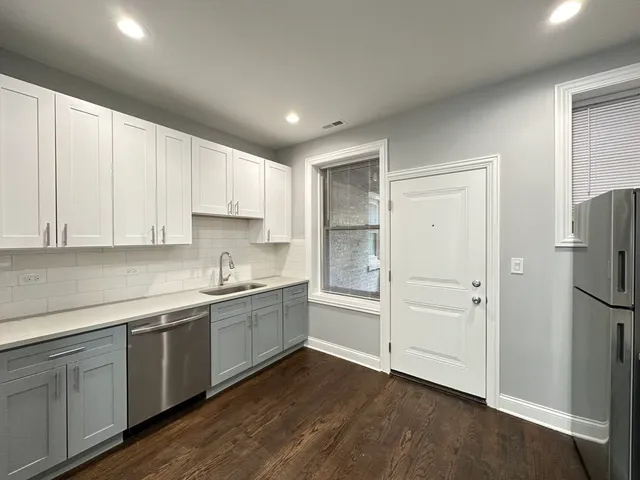 a kitchen with a sink a refrigerator and cabinets