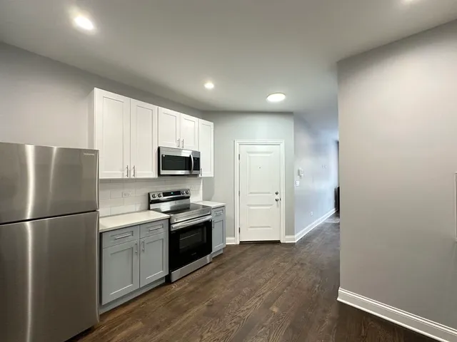 a kitchen with stainless steel appliances granite countertop a refrigerator sink and stove