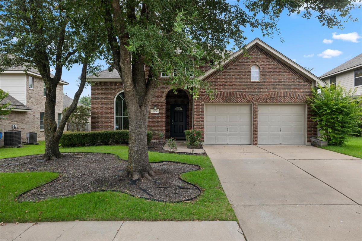 2304 Village View Loop Pflugerville, TX 78660 - Photo 2 of 40 Brick facade with arched details frames the inviting entry and twin garage doors.