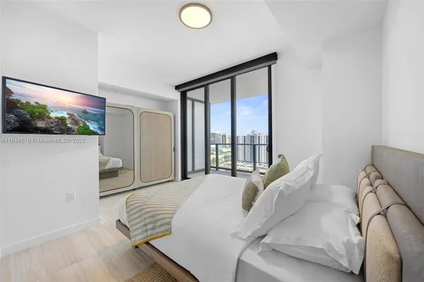 a bedroom with a bed and a flat screen tv
