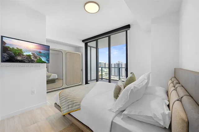 a bedroom with a bed and a flat screen tv