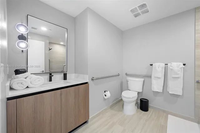 a bathroom with a sink a toilet and a mirror