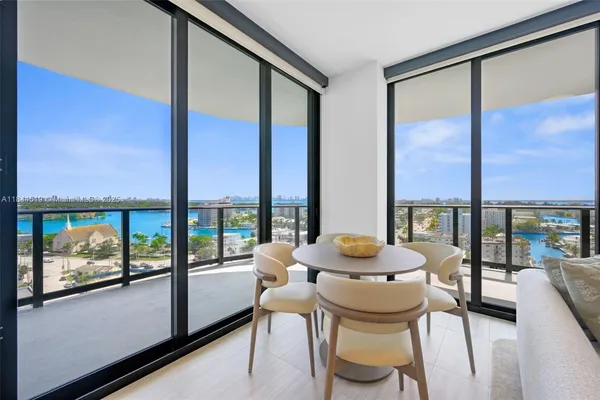 a dining room with furniture and a floor to ceiling window