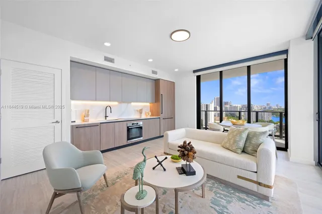 a living room with stainless steel appliances kitchen island granite countertop furniture a rug kitchen view and a large window