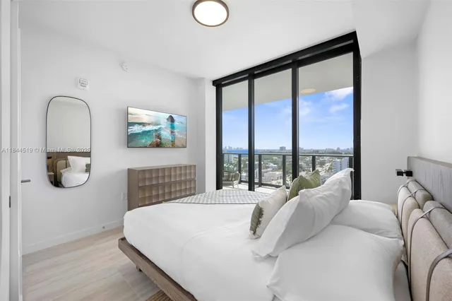 a bedroom with a bed and a large window