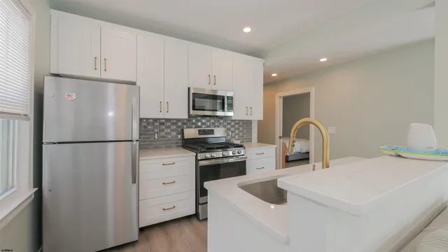 a kitchen with white cabinets and stainless steel appliances