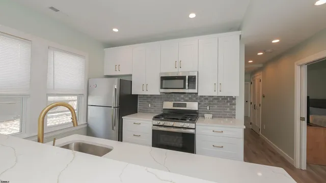 a kitchen with white cabinets and stainless steel appliances