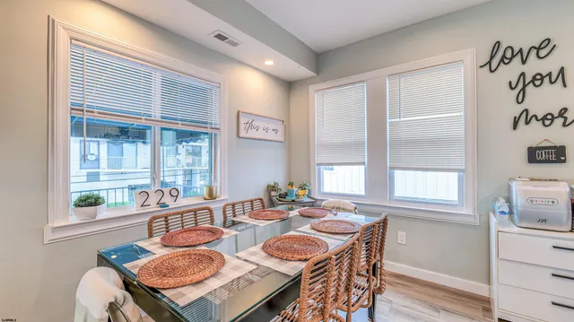a dining room with furniture a large window and wooden floor