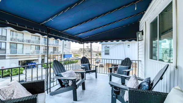 a view of a porch with furniture and a yard