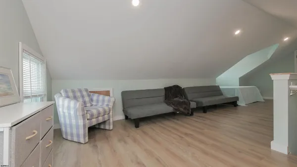 a bedroom with a large bed and wooden floor