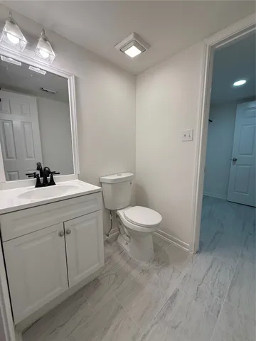 a bathroom with a toilet a sink and mirror