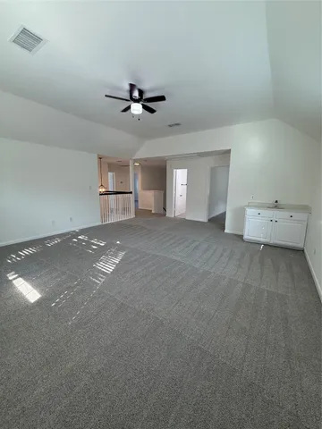 an empty room with a window and ceiling fan
