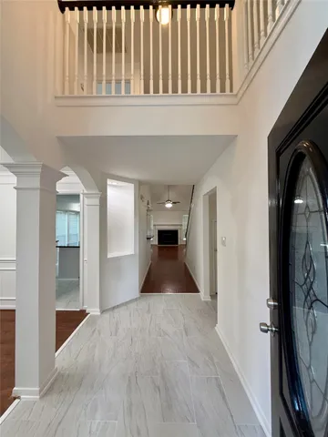 a view of a hallway with wooden floor and staircase