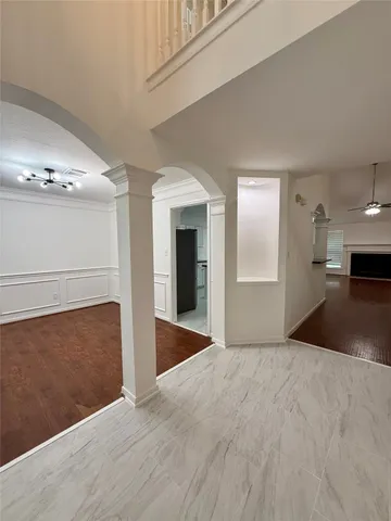 a view of an empty room with kitchen and a window