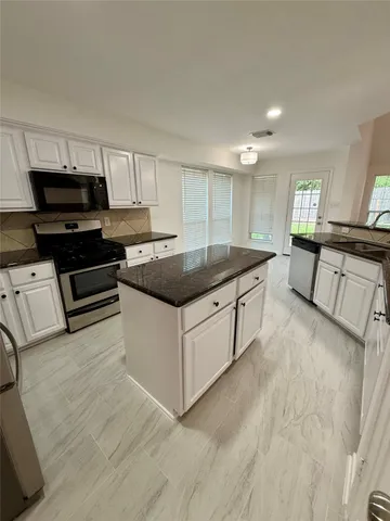 a kitchen with stainless steel appliances granite countertop a sink and a stove